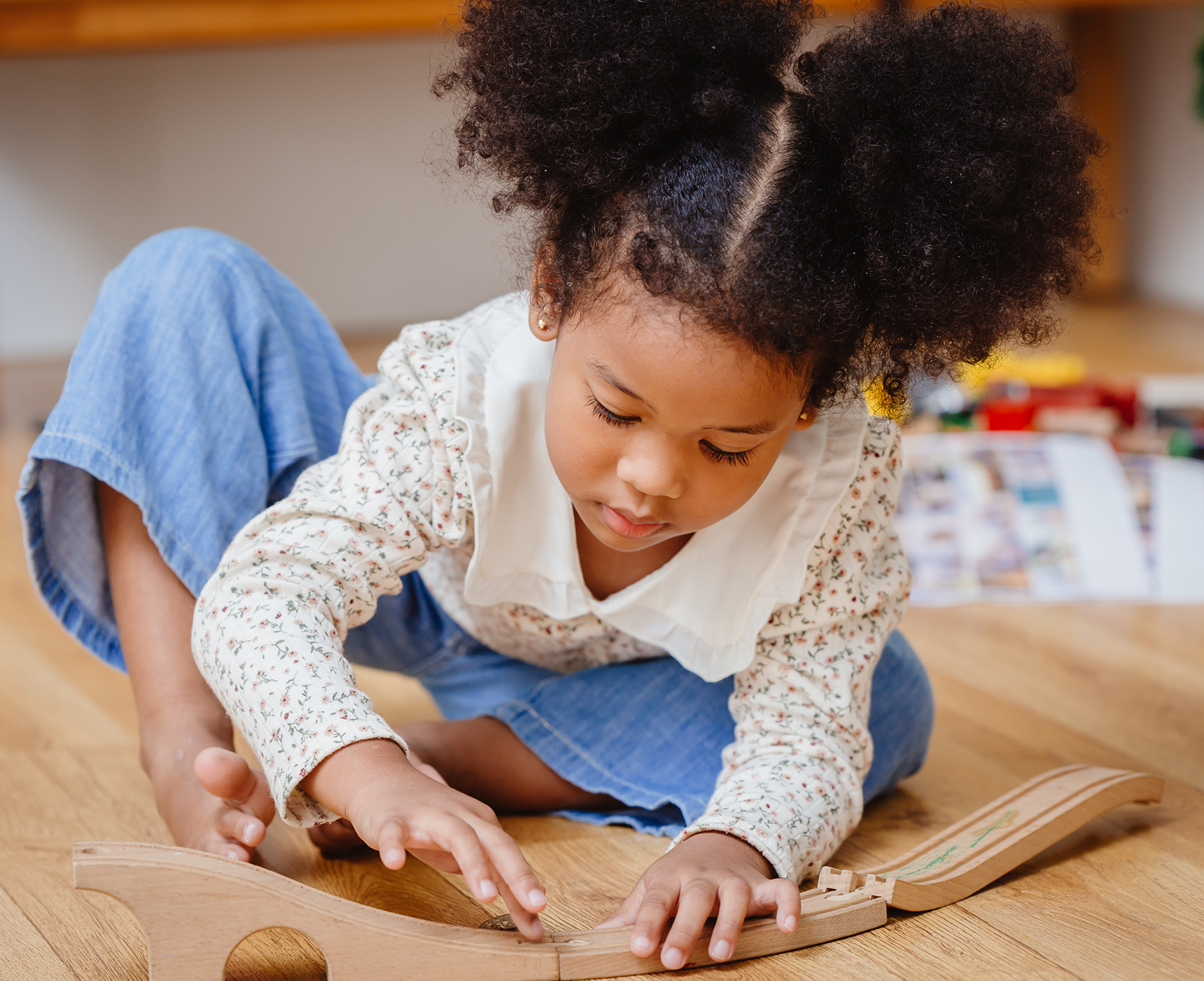 little cute child girl enjoy playing wood puzzle on the wooden floor at home in living room.